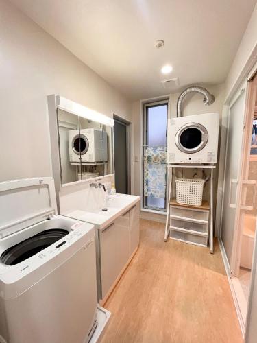 a kitchen with a sink and a washing machine at Shima Stay holoholo in Zamami