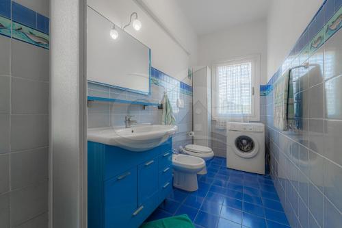 a blue and white bathroom with a toilet and a sink at Silvia sul Lungomare di Campo in Marina di Campo
