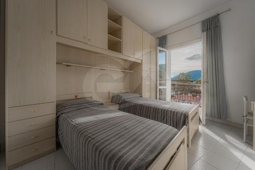 two beds in a room with a window at Silvia sul Lungomare di Campo in Marina di Campo