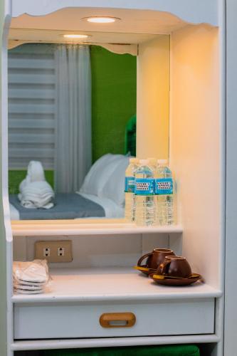 a cabinet with two bottles of water and a mirror at The Stackey Hotel in Olongapo