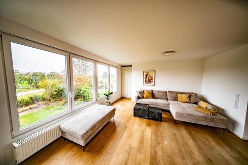 a living room with a couch and a large window at Ferienwohnung Auerose in Wesel