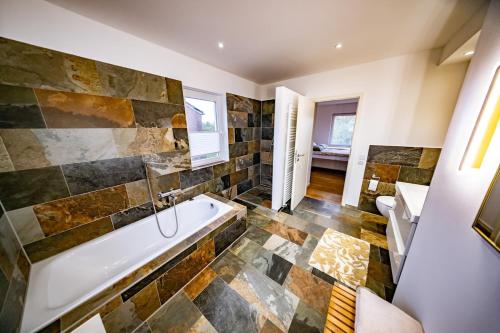 a large bathroom with a tub and a sink at Ferienwohnung Auerose in Wesel