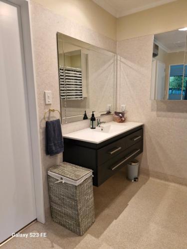 a bathroom with a sink and a mirror at Peaceful Rural Cottage in Kopuaranga