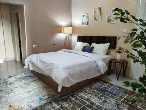 une chambre avec un lit avec des draps blancs et un tapis dans l'établissement Moon Homes in Downtown Cairo, au Caire