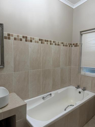 un baño con bañera y lavabo en Harbour View Selfcatering, en Mossel Bay
