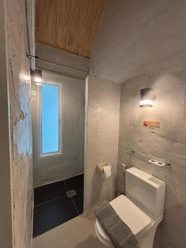 ein kleines Badezimmer mit Toilette und Fenster in der Unterkunft Dehut Boutique Homestay hut2 in Khon Kaen