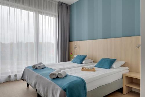 a hotel room with two beds with towels on them at Hotel Zatoka in Gdańsk