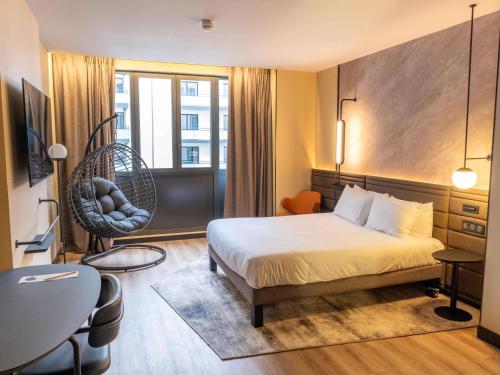 ein Hotelzimmer mit einem Bett und einem Stuhl in der Unterkunft Novotel Rouen Centre Cathédrale in Rouen