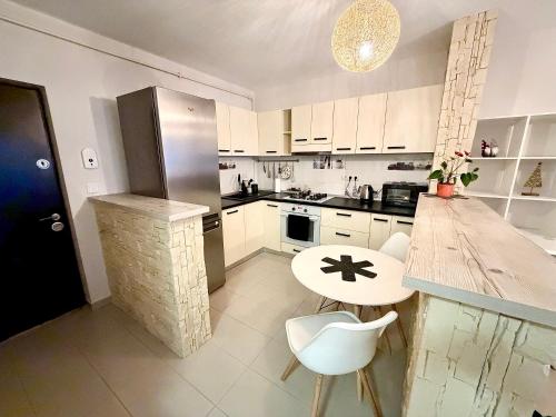 eine Küche mit weißen Schränken und einem Tisch und Stühlen in der Unterkunft FLH - Obralix Home in Sibiu