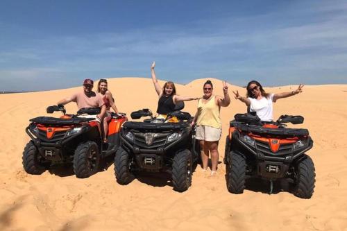 a group of people standing in the sand with atvs at Villa Biển Vàng Beach Front in Bình Sum