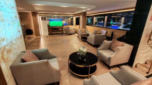 een woonkamer met stoelen en een tafel en een televisie bij ارجان المتميزة للشقق المخدومة in Jeddah