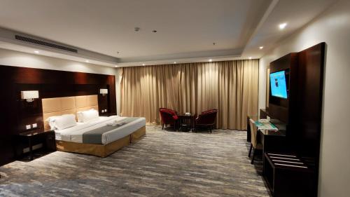een hotelkamer met een bed en een flatscreen-tv bij ارجان المتميزة للشقق المخدومة in Jeddah