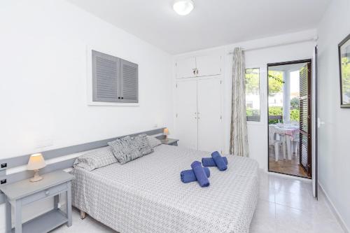 a bedroom with a bed with blue pillows on it at Apto Familiar frente a cala in Cala en Forcat