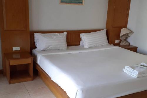 a bedroom with a large white bed and two night stands at Praew Mansion in Kamala Beach
