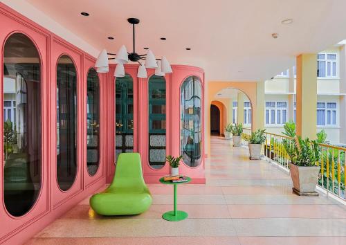 a hallway of a building with pink walls and a green bench at Miami Hotel Bangkok in Bangkok