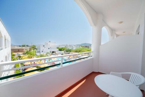 a balcony with two chairs and a view of a city at Astron Hotel Rhodes in Rhodes Town