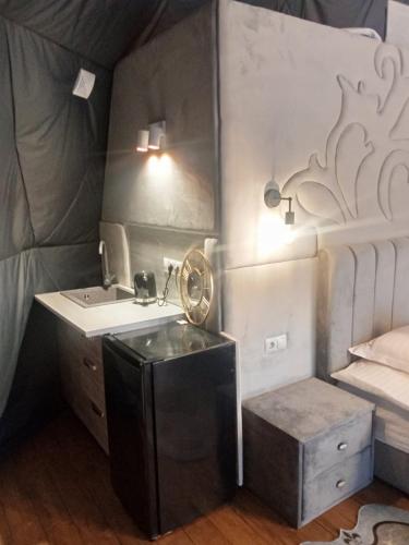 a small bathroom with a sink and a bed at Глемпінг Перлина Карпат in Dragobrat