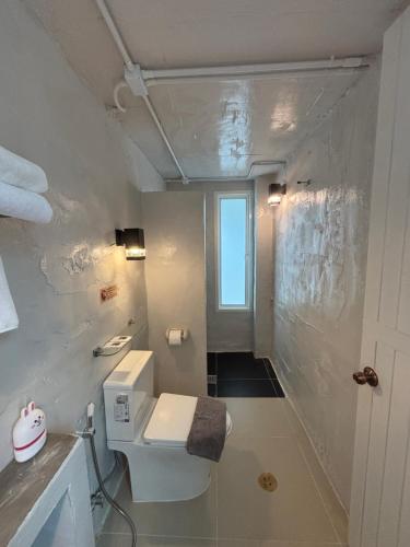 ein weißes Badezimmer mit Toilette und Dusche in der Unterkunft Dehut Boutique Homestay hut1 in Khon Kaen