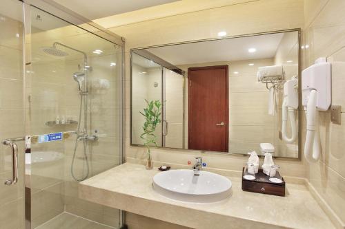 ein Badezimmer mit Waschbecken und Dusche in der Unterkunft Guilin China Southern Pearl Hotel in Guilin