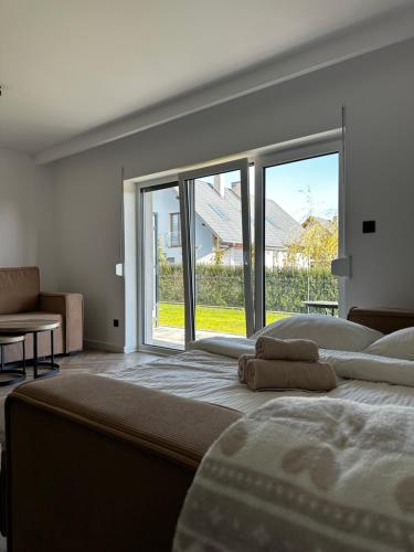 a bedroom with two beds and a large window at Verde Klon Apartment- Lotnisko Jasionka in Jasionka