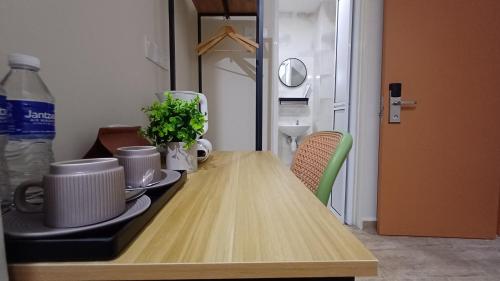 a wooden table with cups and plates on top of it at Swing and Pillows - Jalan Changkat Thambi Dollah in Kuala Lumpur