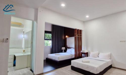 a hotel room with two beds and a bathroom at Landed Spacious House at Cangkat Delima Gelugor Penang in Gelugor