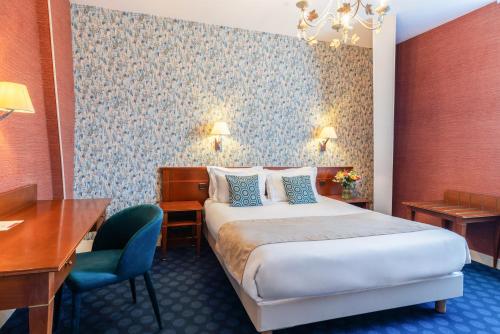 a hotel room with a bed and a desk at The Originals Boutique, Hôtel Normandie, Auxerre in Auxerre