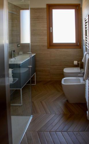 a bathroom with a toilet and a sink at Vie D'Alt Wine and Rooms in Prepotto