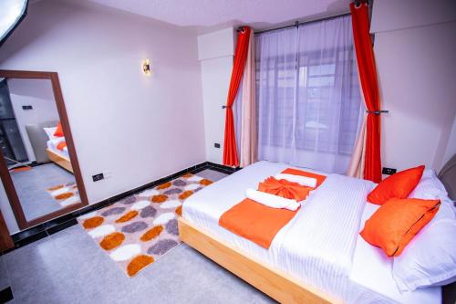 una camera da letto con un letto con tende rosse e uno specchio di Most Executive house in Naka Lakeview & central a Nakuru
