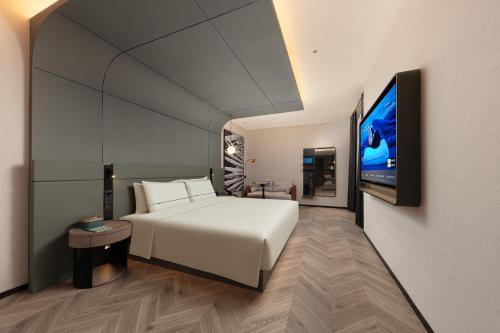 a bedroom with a white bed and a flat screen tv at Atour S Hotel Beijing International Trade CBD Jianguo Men in Beijing