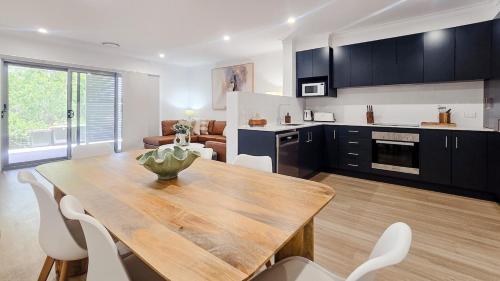 a kitchen and dining room with a wooden table and chairs at Kincaid Travellers Townhouse - Central Wagga in Wagga Wagga