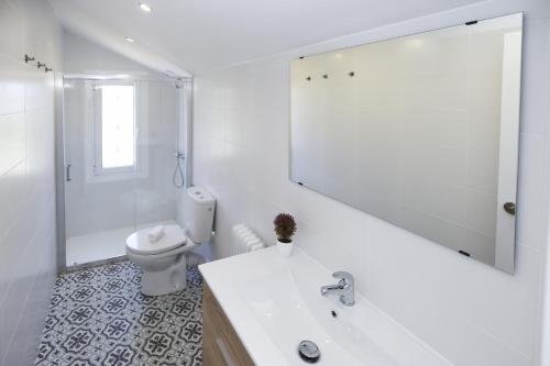 a bathroom with a sink and a toilet and a mirror at Villa ADELFA in Salou