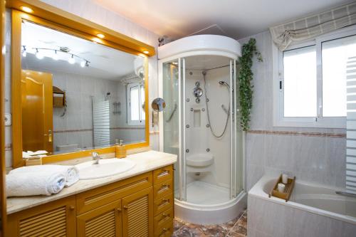 a bathroom with a shower and a sink and a tub at PLUMA VILLA - Only Families in Salou