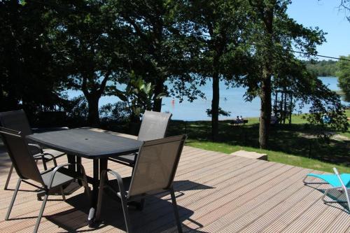 a table and chairs on a deck with a view of the water at Mobilheim Zweiundvierzig In Lychen in Lychen