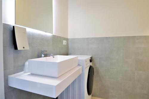 a bathroom with a sink and a washing machine at Venice Terminal Apartments & Suites in Mestre