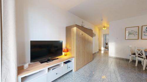 a living room with a flat screen tv on a cabinet at strandnahe FeWo mit Schwimmbad im Haus, a cappella 68,Binz in Binz