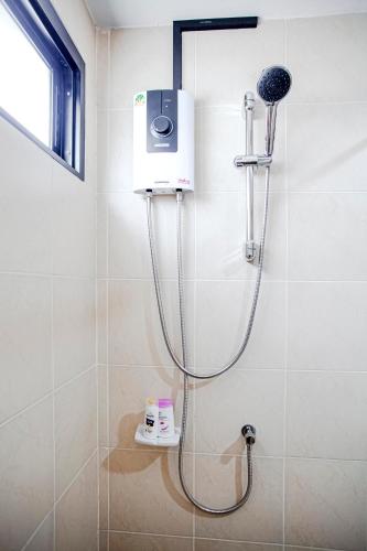a shower in a bathroom with a blow dryer at Stay White Orchid in Krabi