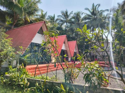 a row of bungalows in a resort with palm trees at Rustic Palms in Thāl