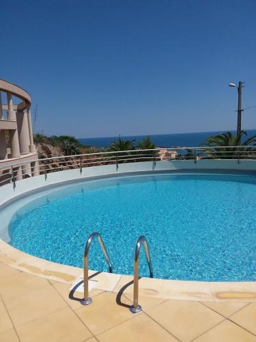 a large pool with blue water in a building at Lagune Azur – Séjour cosy vue mer piscine Wi-Fi in Sète
