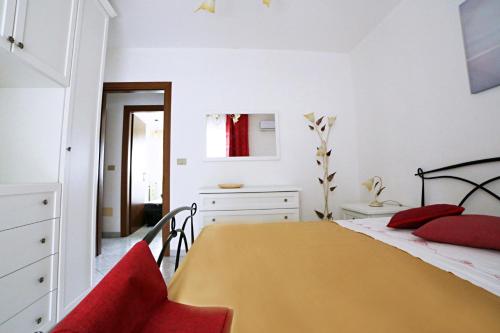 een slaapkamer met een geel bed met rode kussens bij A Casa di Doralucia - Comfort a Santa Maria di Leuca in Leuca