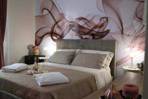 a bedroom with a bed with a painting on the wall at Terra Sinus Luxury apartment in Terrasini