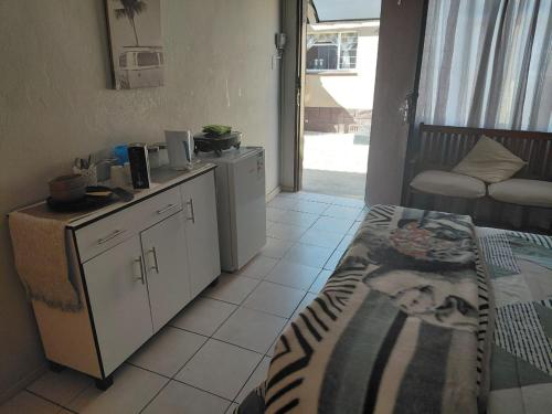 a room with a bedroom with a bed and a table at Germiston Residential Motel in Germiston