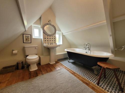 y baño con bañera, aseo y espejo. en Old school house surrounded by countryside, en Earls Colne