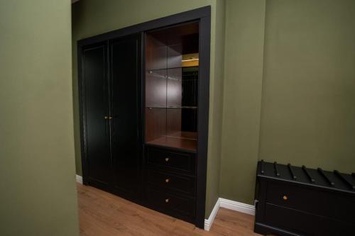 ein Schrank mit einem schwarzen Schrank in einem Zimmer in der Unterkunft Private garden room by MANAGR in Timisu de Jos