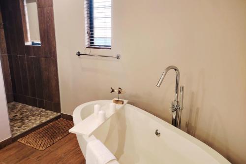 a white bath tub in a bathroom with a window at Dierama Dream, Cathkin Estates - 4 adults and 2 children, 12 years or younger in Ardmore