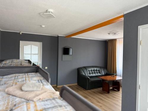 a bedroom with a bed and a couch and a chair at ADAM Hostel Krāslava in Krāslava