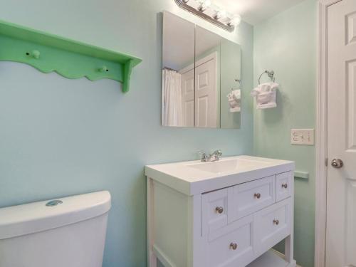 タイビーアイランドにあるTybee Tyme Lowerの白い洗面台と鏡のあるバスルーム