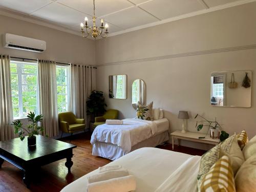 a living room with two beds and a table at Le Manse in Franschhoek