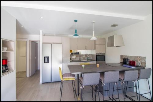 a kitchen with a table and chairs in a room at L'ariot 1984 - appartement cosy avec terrasse, parking et wifi in Sète