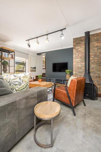 a living room with a couch and a fireplace at Avemore Time Out Le Verger in Stellenbosch